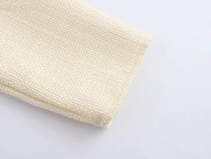 Dettaglio della trama del tessuto in tweed beige e delle cuciture dell'abito blazer