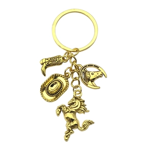 Antique gold western cowboy hat, boot, and horse pendant keychain in professional studio shot
