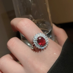 Gros plan détaillé d'une bague en argent avec rubis ovale et double halo de zircons