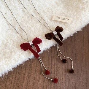 Detailed view of velvet bow necklaces with zircon center and silver snake chain