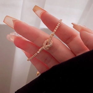 Elegant gold plated knot bracelet with pavé cubic zirconia on woman's wrist