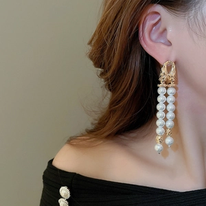Close-up of elegant double-layer pearl tassel earrings with gold-tone hollow sphere details
