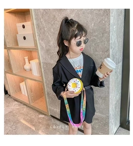Close-up of a child wearing a white donut-shaped silicone crossbody bag with rainbow strap