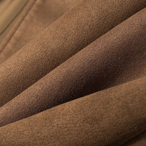 Detailed macro view of soft brown faux suede fabric texture and smooth fine fiber finish