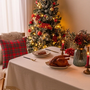 Warm Christmas table setting with beige lace tablecloth and festive floral decor