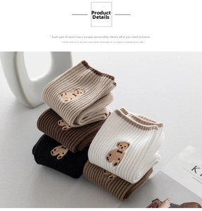 Detail of ribbed cotton mid-calf socks with cute bear embroidery in earth tone colors