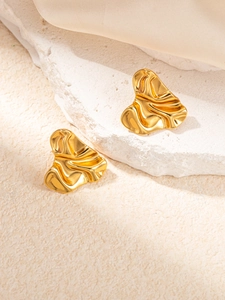Detail of gold geometric irregular crumpled metal stud earrings with abstract heart shape