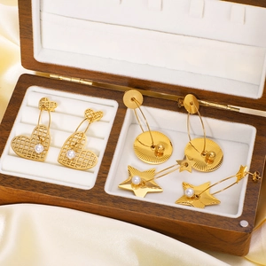 Gold-plated stainless steel star and heart earrings with pearls on a satin background