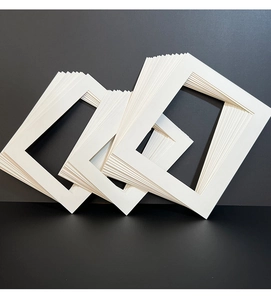 Close-up of stacked white photo frame mats showing thick texture and rectangular cutouts