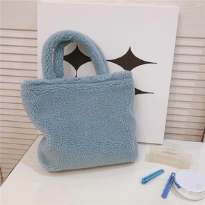 Dettaglio della morbida borsa tote in peluche azzurro con trama in pile e doppi manici