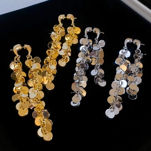 Vue détaillée de longues boucles d'oreilles à disques métalliques en or et argent