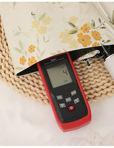 Digital lux meter measuring light transmittance on floral parasol fabric detail