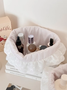 Detail of pink plaid fabric lining and delicate lace trim on a mini storage basket
