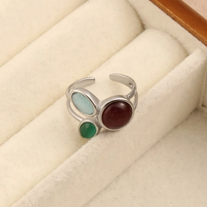 Détail d'une bague réglable en argent avec trois pierres ovales bleues, rouges et vertes