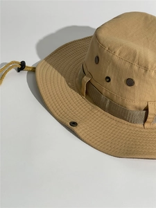 Detail of khaki outdoor sun hat featuring metal vents and adjustable chin strap cord