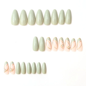 Elegant green almond press-on nails with minimalist gold lines and sparkling rhinestones