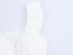 Detail view of white dress with jacquard texture, ruffle straps and size S label
