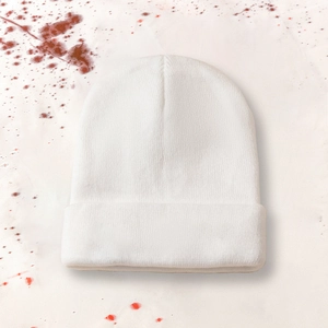 Close-up of white cuffed knit beanie with pumpkin embroidery texture and fine weave