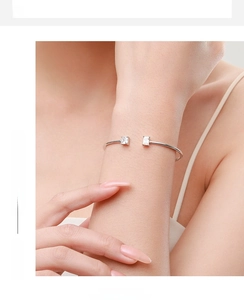 Detailed view of an S925 sterling silver open bracelet with two square-cut cubic zirconias