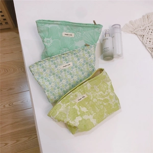 Detail view of three floral jacquard canvas makeup bags with zip and simple wish label