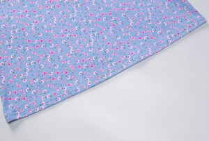 Détail de l'ourlet de la robe d'été bleu clair avec des motifs de roses roses et de fleurs