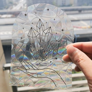 Holographic suncatcher film detail showing black crystal and hand line art pattern