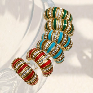 Détail de boucles d'oreilles créoles dorées 18K avec émail coloré et cristaux incrustés