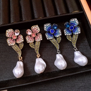 Détail macro de boucles d'oreilles fleurs rétro avec strass et perles baroques élégantes
