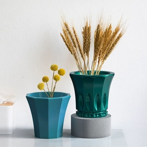 Detailed view of faceted striped vase mold and relief style storage container on a stand