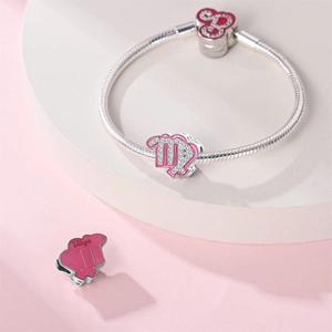 Detailed view of Virgo zodiac charm with pink enamel on a silver snake chain bracelet