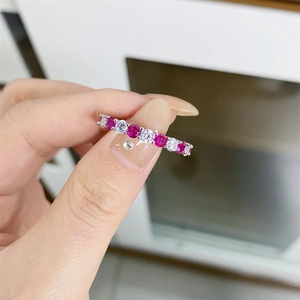 Close-up of S925 sterling silver ring with red and white gemstones held by hand