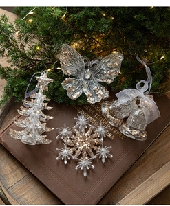 Dettaglio degli ornamenti natalizi in acrilico a forma di albero e farfalla con paillettes