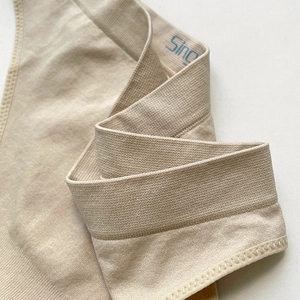 Elastic seamless beige thong for women with breathable knit fabric and side branding
