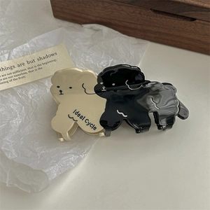 Detail of cute puppy hair clips in cream and black with Ideal Cycle text engraving