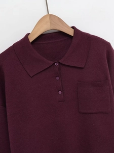 Detail of burgundy polo neck knit sweater showing button placket and chest pocket