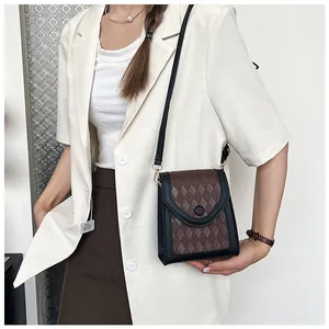 Détail de la texture matelassée et de la boucle ronde du mini sac à bandoulière bicolore