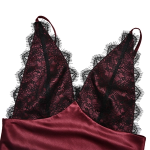 Close-up of wine red satin camisole dress featuring black lace trim at the neckline