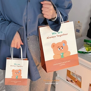 Detail view of cartoon bear gift bags in two sizes with white woven handles and illustrations