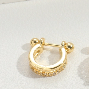 Detailed view of U-shaped gold nose ring with sparkling pavé cubic zirconia accents