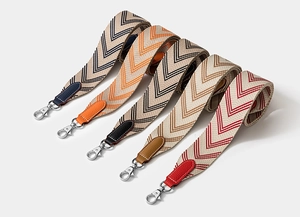 Detail of woven jacquard shoulder straps with leather ends and silver metal clips