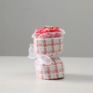 Detail of pink soap rose bouquet wrapped in pink white plaid cloth with white ribbon bow
