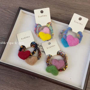 Lot de quatre chouchous en laine feutrée en forme de cœur aux couleurs assorties