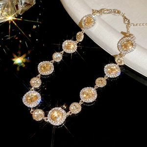 Makroaufnahme einer Goldkette mit gelben runden Edelsteinen und Diamant-Halo-Fassung