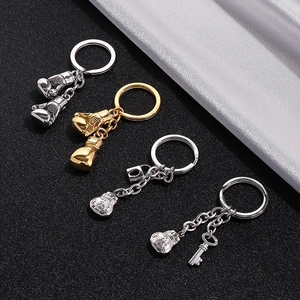 Macro view of polished stainless steel boxing gloves and lucky bag keychain charms