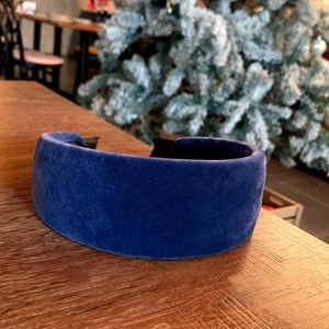 Detail of deep blue velvet wide headband with soft texture and plush padded design