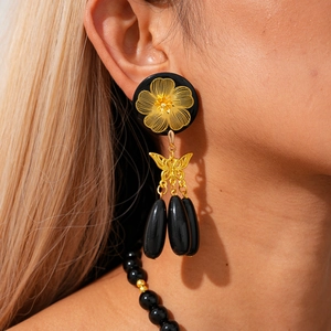 Detail of vintage black resin beaded necklace and butterfly drop earrings on model