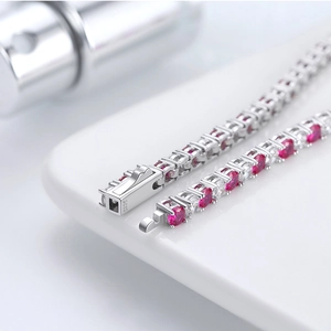 Macro shot of silver S925 tennis bracelet clasp with red and white zircon stones