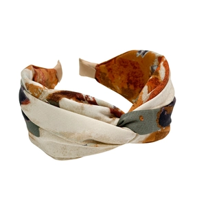 Abstract tie-dye pattern fabric headband with criss-cross design in orange and beige