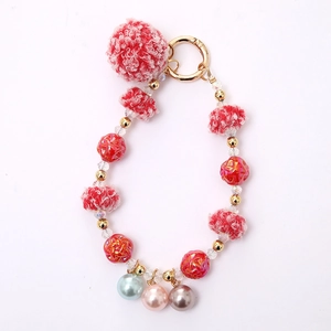 Furry red and pink plush ball keychain with textured beads and golden metal clasp for bags