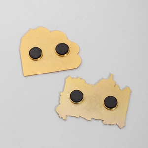 Detail view showing strong circular black magnets on the back of gold metal souvenirs